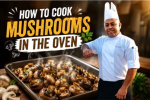 Chef in a white uniform and hat standing beside a tray of roasted mushrooms, with bold text reading “How to Cook Mushrooms in the Oven” and a cooking tutorial style background.