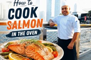Professional chef beside a baked salmon fillet with lemon and vegetables, illustrating a step-by-step guide on how to cook salmon in the oven.
