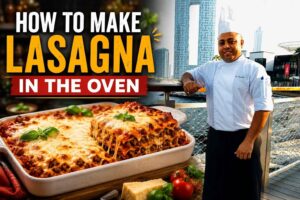Feature image for a lasagna cooking tutorial. A smiling chef in a white uniform and tall chef’s hat stands on a waterfront promenade with a modern city skyline in the background. Beside him is a large, freshly baked lasagna topped with melted golden cheese and basil leaves. Bold text reads “How to Make Lasagna” with a red banner underneath that says “In the Oven.” The image uses bright colors and a split-screen layout to highlight both the chef and the finished dish.