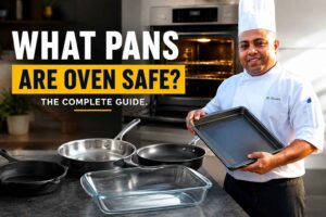 Chef in a white uniform and tall chef hat stands in a modern kitchen holding a baking sheet beside an open oven. Various cookware—including a cast-iron skillet, stainless-steel pan, nonstick pan, and glass baking dish—are displayed on a countertop. Large headline text reads, “What Pans Are Oven Safe? The Complete Guide.” The image is designed as a feature graphic for an article about oven-safe cookware.